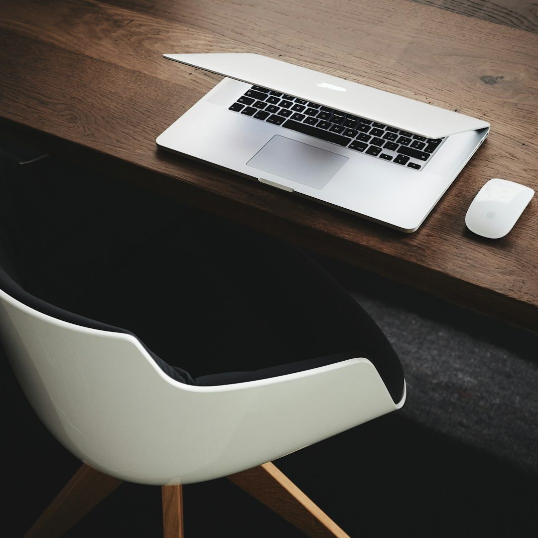 Smartphone neben einer Kaffeetasse und Pflanzen auf einem Tisch, Ohrhörer daneben.